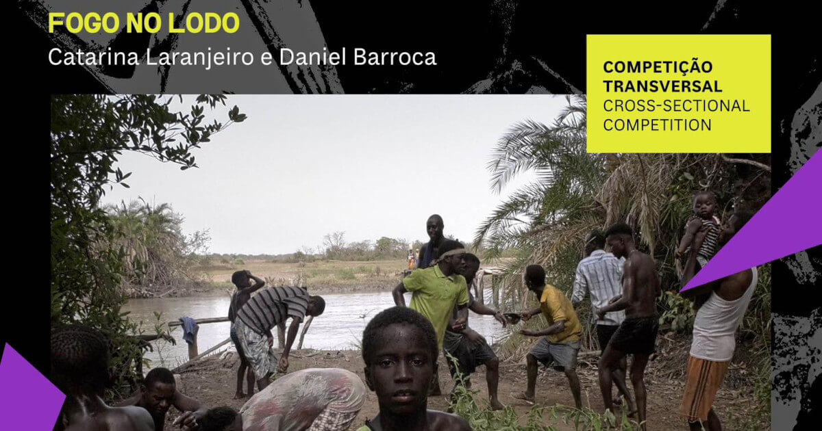 Imagem do filme "Fogo no Lodo" de Catarina Laranjeiro e Daniel Barroca, onde se vêm um grupo de meninos e homens adultos negros junto a um rio. Em primeiro plano, um menino olha directamente para a câmara.